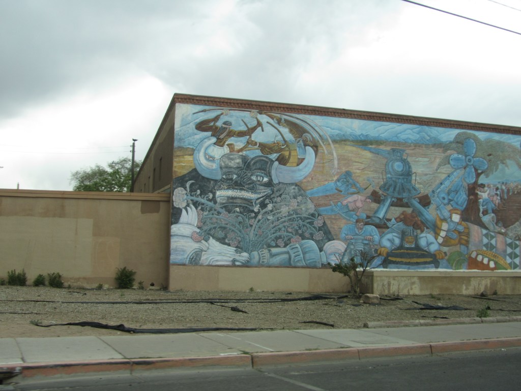 A colorful mural depicting mythical and historical themes, featuring a large figure with horns amidst various characters and elements representing culture and history.